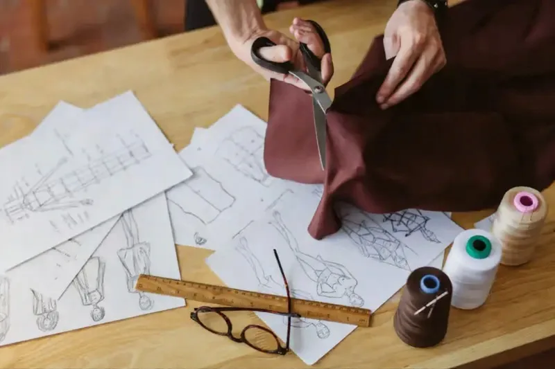 Tailor preparing paper patterns for a leather jacket design before cutting the hide
